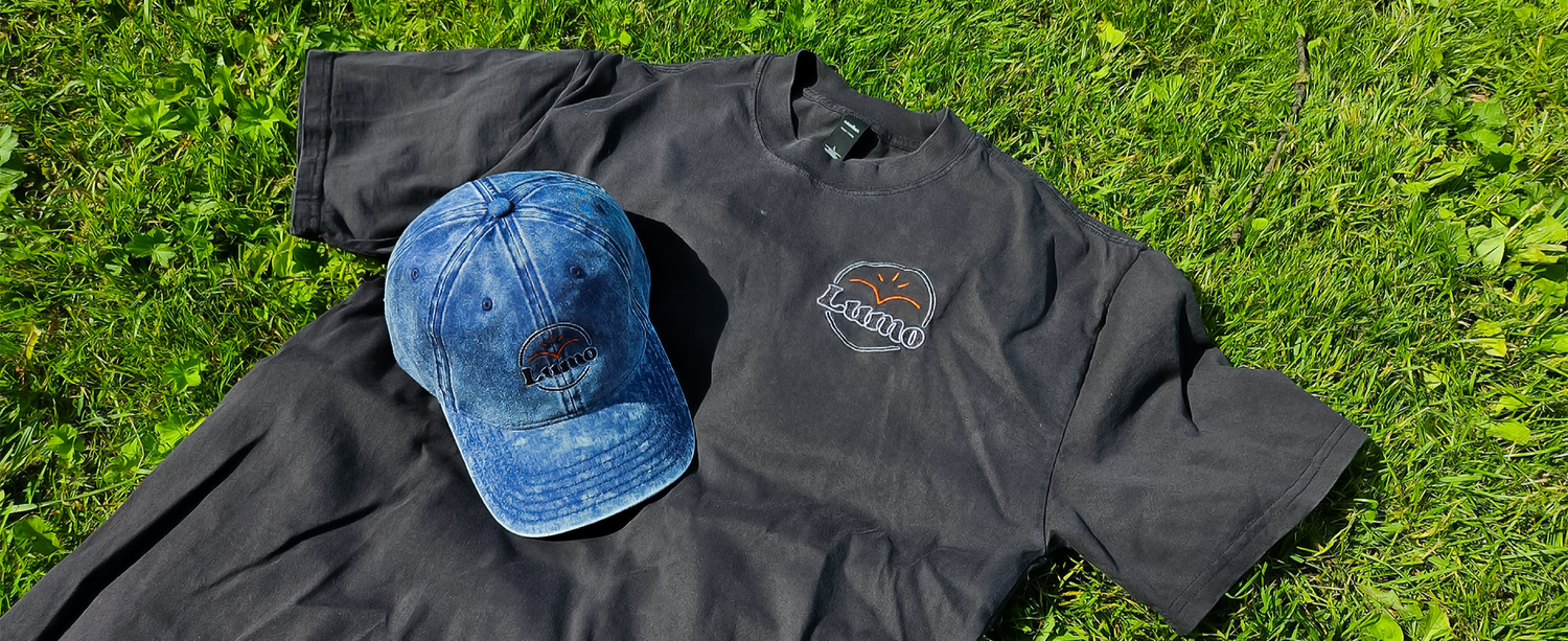 Black sweatshirt with a logo and blue cap on grass